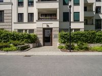 a view of the outside of a building with green shutters and landscaping on the side