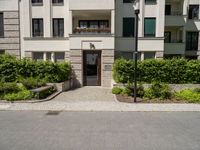 a view of the outside of a building with green shutters and landscaping on the side