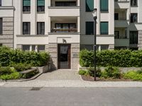 a view of the outside of a building with green shutters and landscaping on the side