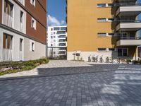 two buildings with bikes parked in a driveway outside it at the bottom of the building