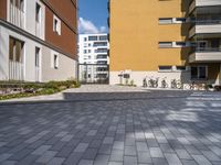 two buildings with bikes parked in a driveway outside it at the bottom of the building