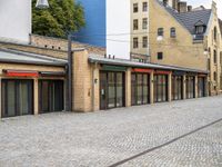 a paved street that has windows in it and a few buildings on it with a red sign