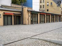 a paved street that has windows in it and a few buildings on it with a red sign