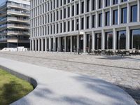 a brick building with glass windows and sidewalk leading to it and a black fire hydrant
