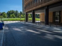 a road through which is a large modern building with an awning over it's entrance