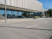 an empty parking lot in front of an office building with an open front door and glass windows