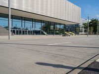 an empty parking lot in front of an office building with an open front door and glass windows