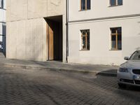 a person with a suitcase walking across an outside courtyard in front of a building,