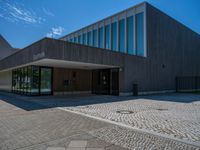 the entrance to an office building has several square glass doors on each side of it