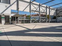 a man on a skateboard in the middle of the court and on the other side a building