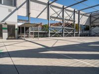 a man on a skateboard in the middle of the court and on the other side a building