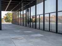 the columns on the building are lined up with glass and silver panels on the outside walls