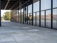 the columns on the building are lined up with glass and silver panels on the outside walls