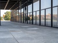 the columns on the building are lined up with glass and silver panels on the outside walls