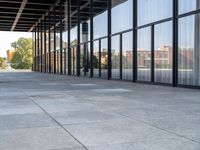 the columns on the building are lined up with glass and silver panels on the outside walls