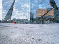 a photo of a building reflecting in another building's glass windows with cobbles