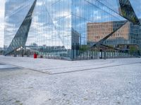 a photo of a building reflecting in another building's glass windows with cobbles