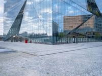 a photo of a building reflecting in another building's glass windows with cobbles