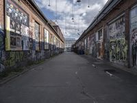 graffiti adorns the walls of an industrial area in an alleyway along a busy street