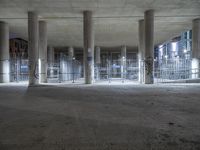 a large concrete structure with white pillars and many graffiti all over it, and lights on