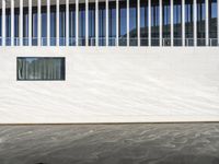 a reflection of another building on water in front of it and a black fire hydrant near the window