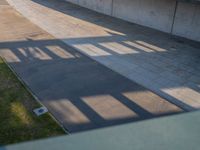 a skateboarder riding on a cement ramp next to a city street under a bridge