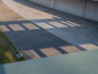 a skateboarder riding on a cement ramp next to a city street under a bridge