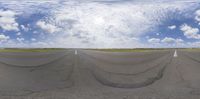 a view of the road in front of the sky from an angled angle, with long stripes of tarmac to the left