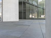 a skateboarder leans against the glass door of an office building's entrance