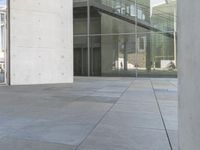 a skateboarder leans against the glass door of an office building's entrance