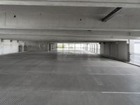 an empty parking garage with one door open for cars to pass by in it that appears to be the middle floor