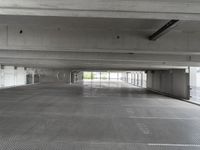 an empty parking garage with one door open for cars to pass by in it that appears to be the middle floor