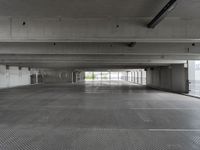 an empty parking garage with one door open for cars to pass by in it that appears to be the middle floor