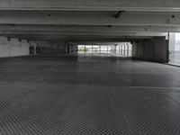 an empty parking garage with one door open for cars to pass by in it that appears to be the middle floor