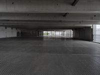 an empty parking garage with one door open for cars to pass by in it that appears to be the middle floor