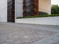 a person riding a skate board in the street on a brick pathway between two tall building