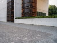 a person riding a skate board in the street on a brick pathway between two tall building