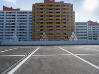 a large apartment building with some white lines in a parking lot with concrete blocks on either side