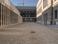 a room with columns near a building with light pouring through it and shadows in the windows