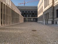 a room with columns near a building with light pouring through it and shadows in the windows