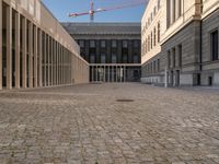 a room with columns near a building with light pouring through it and shadows in the windows