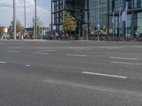 a person riding a motorcycle across an empty street next to a building with a clock on it