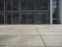 this is a view of an empty patio outside an office building with windows, and a door open