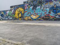 an industrial building with graffiti and another painted wall behind it's wall, outdoors