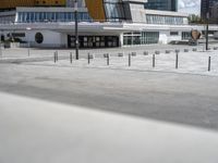 a concrete plaza is outside and buildings are in the background with a blue sky in the middle