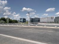 the empty roadway is full of bicycles, with buildings in the background and cars parked along the side