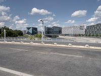 the empty roadway is full of bicycles, with buildings in the background and cars parked along the side