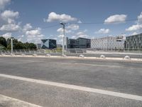 the empty roadway is full of bicycles, with buildings in the background and cars parked along the side