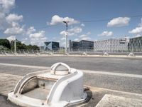 the empty roadway is full of bicycles, with buildings in the background and cars parked along the side