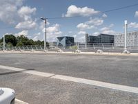 the empty roadway is full of bicycles, with buildings in the background and cars parked along the side